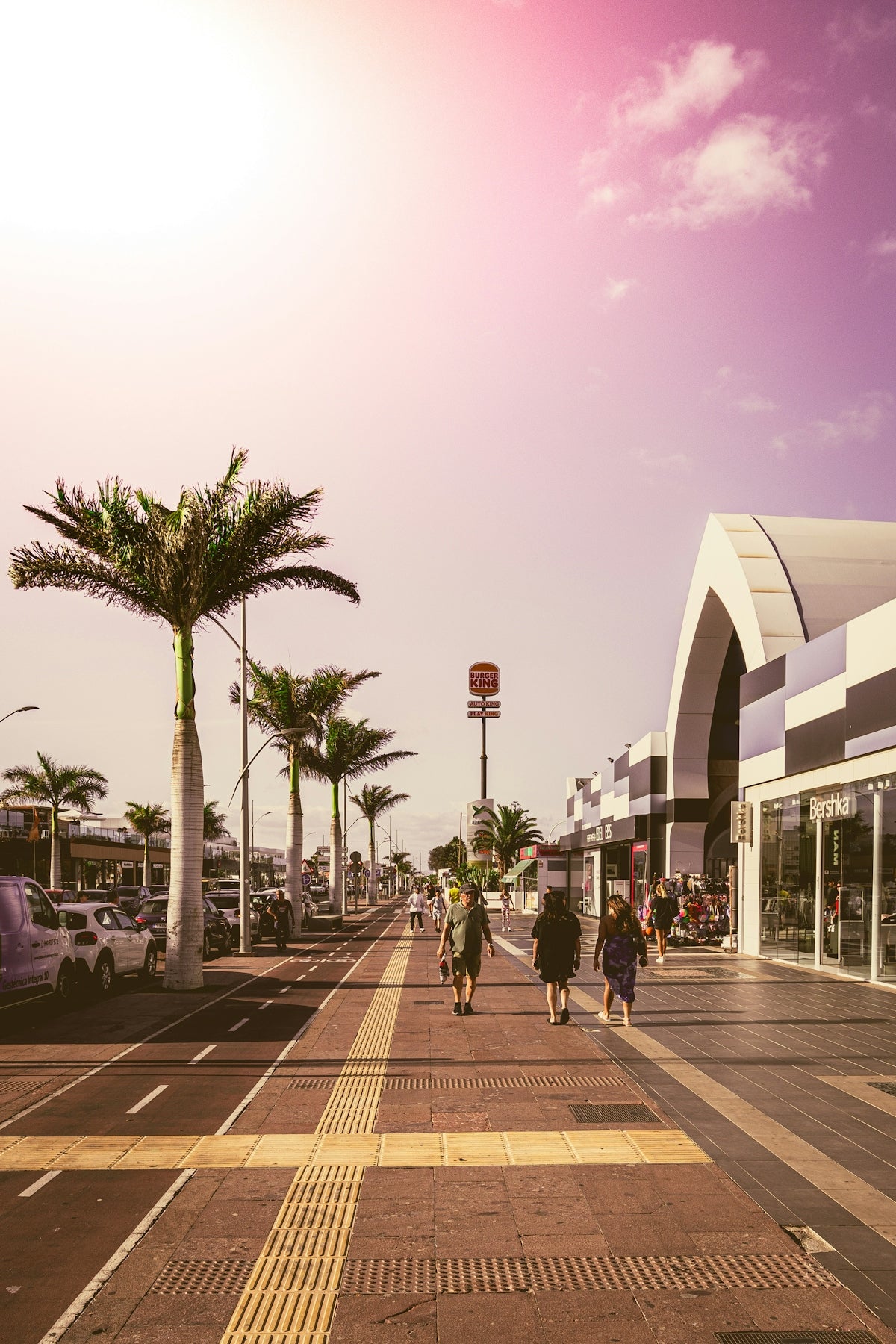 People walking down the sidewalk of a shopping center