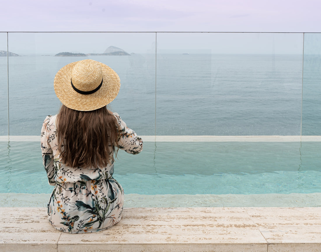 A woman sitting on a bench looking out at the ocean