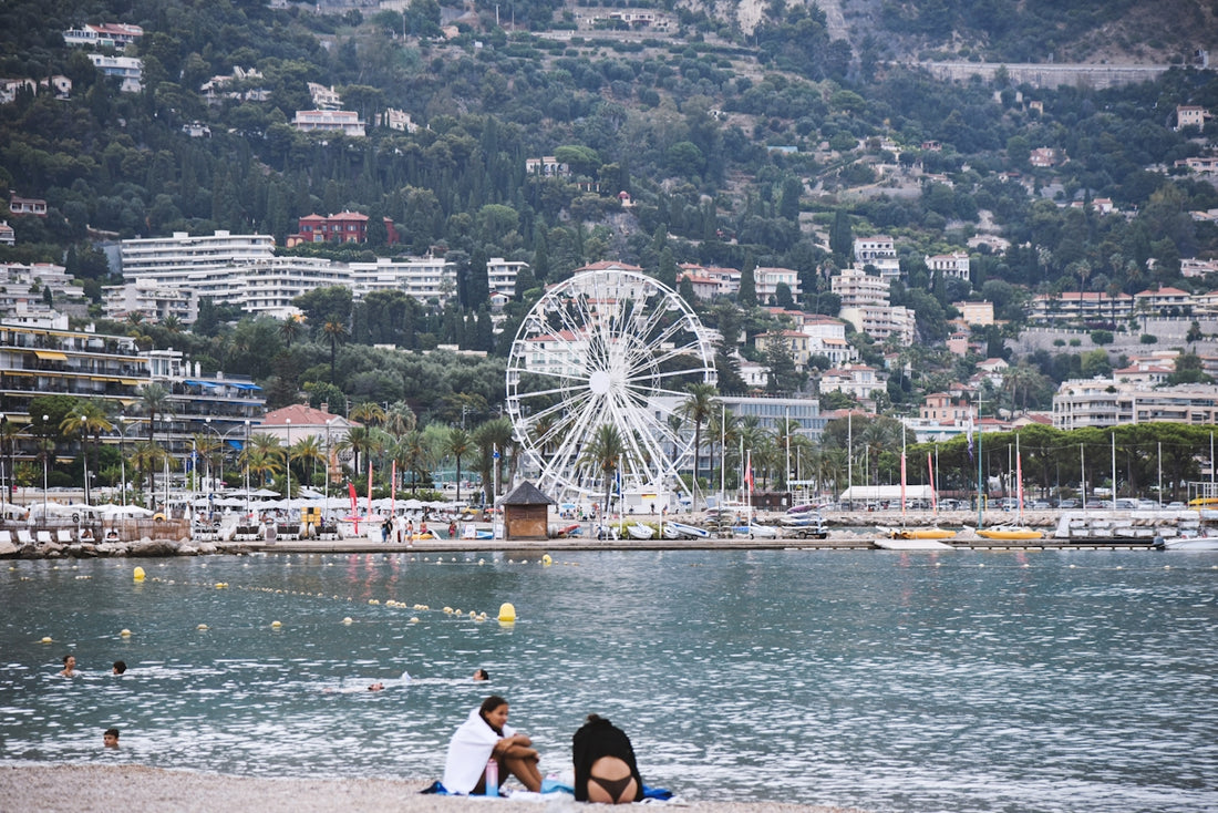Ferris wheel overlooking a coastal town and beach.