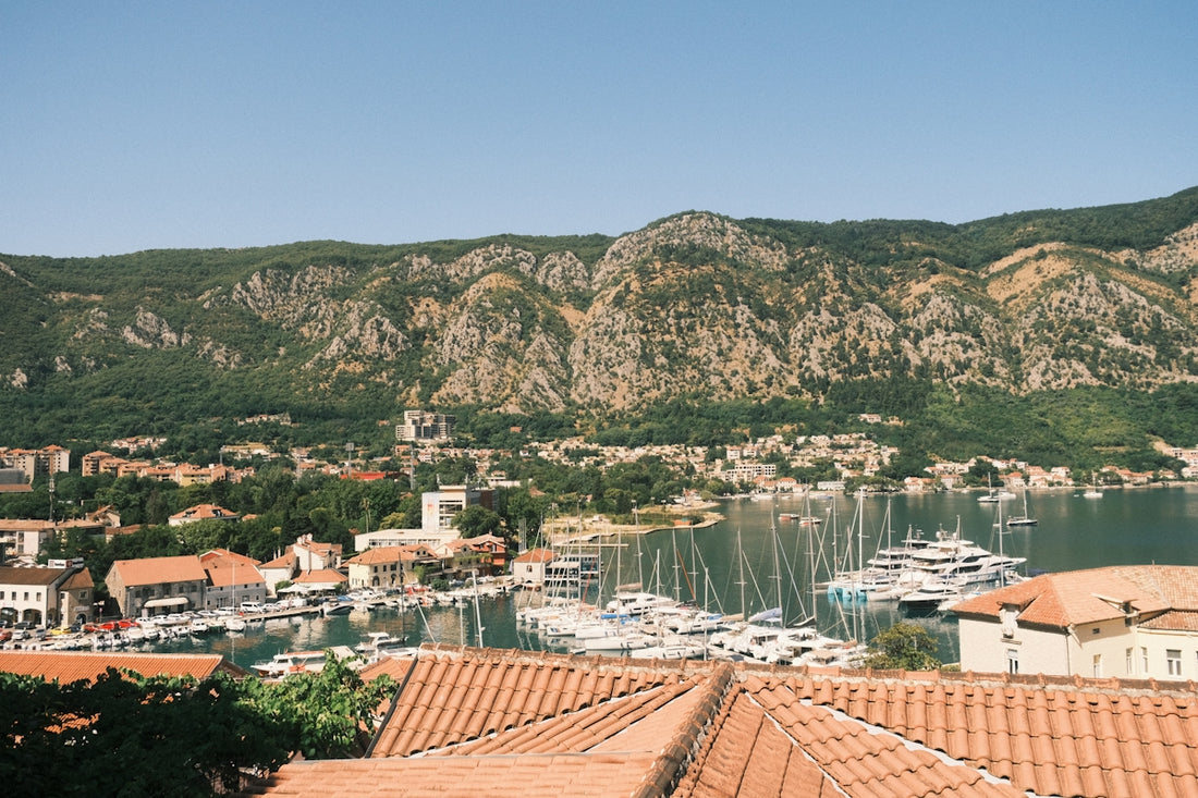 Coastal town with sailboats and mountains in background