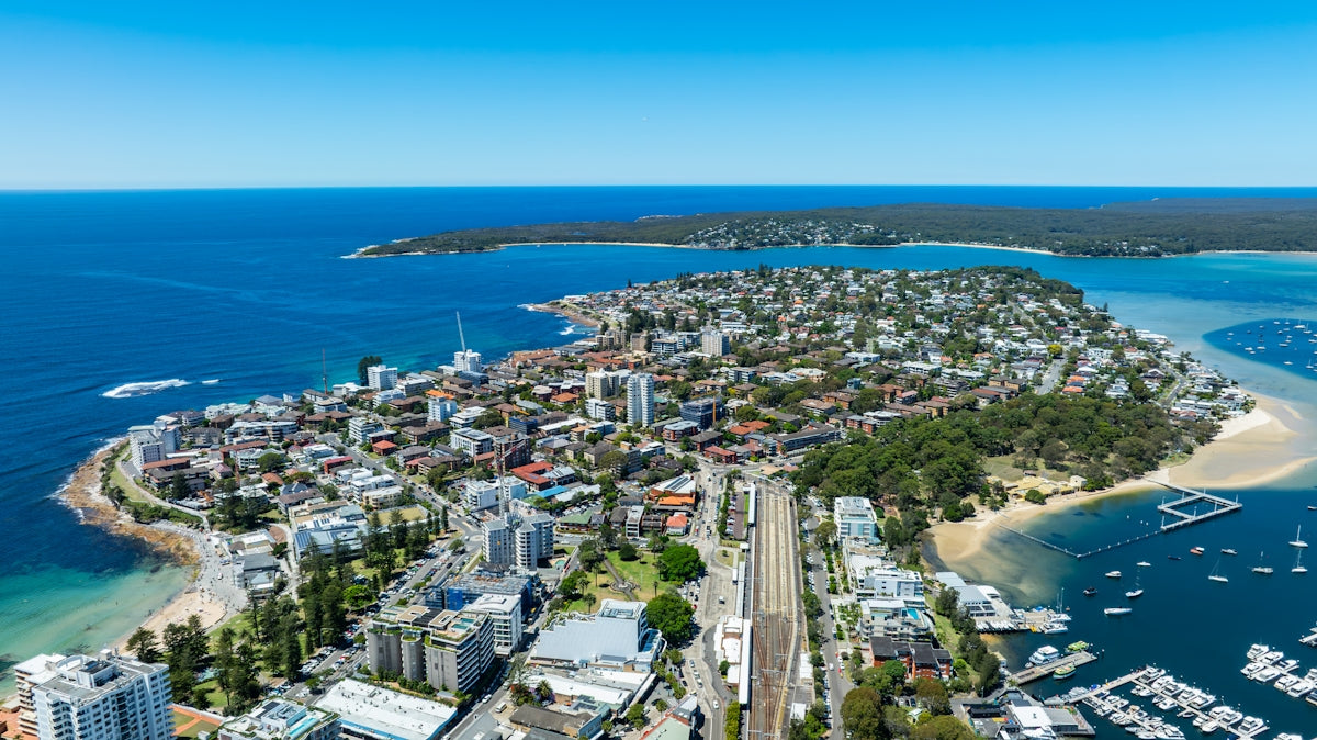 Aerial view of a coastal city with boats and ocean.