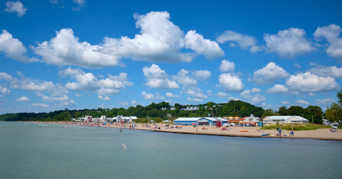 A sunny day at a crowded beach with blue skies.