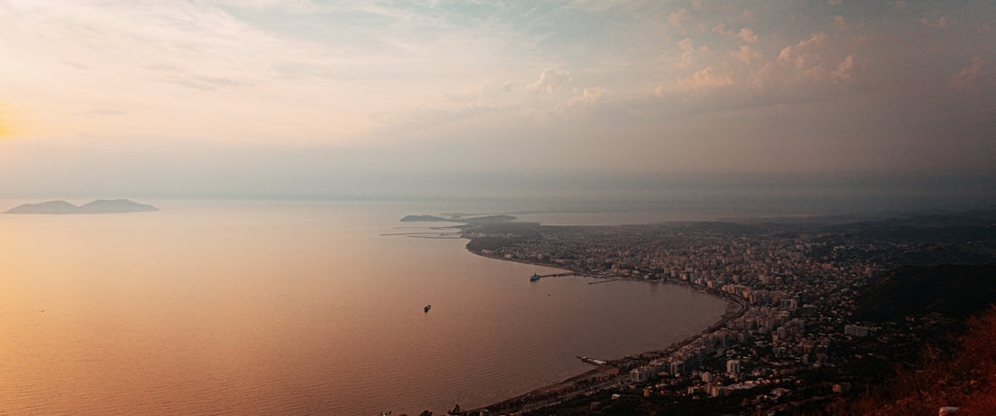 Coastal city skyline at sunset with calm ocean water
