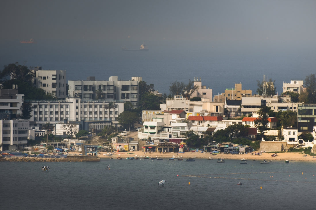 Coastal town with white buildings along a beach and ocean.