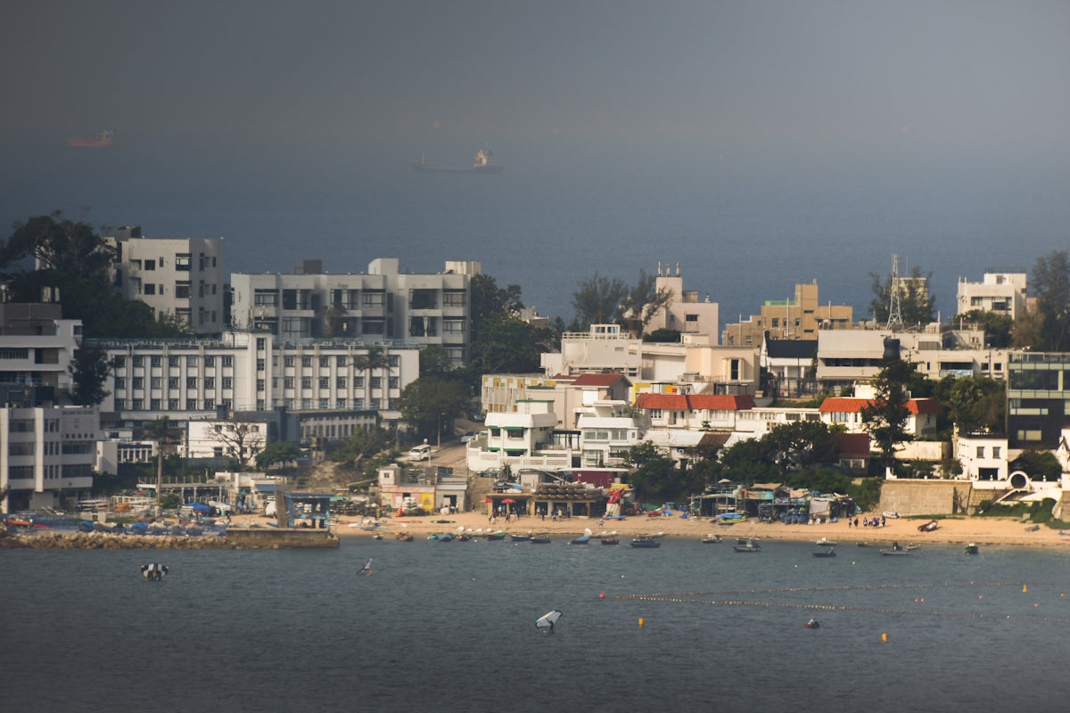 Coastal town with white buildings along a beach and ocean.