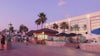 Sunset coastal boardwalk scene with palm trees, beachside shops, and evening vacation atmosphere representing Surfside Wear’s relaxed coastal lifestyle and resort-inspired fashion.